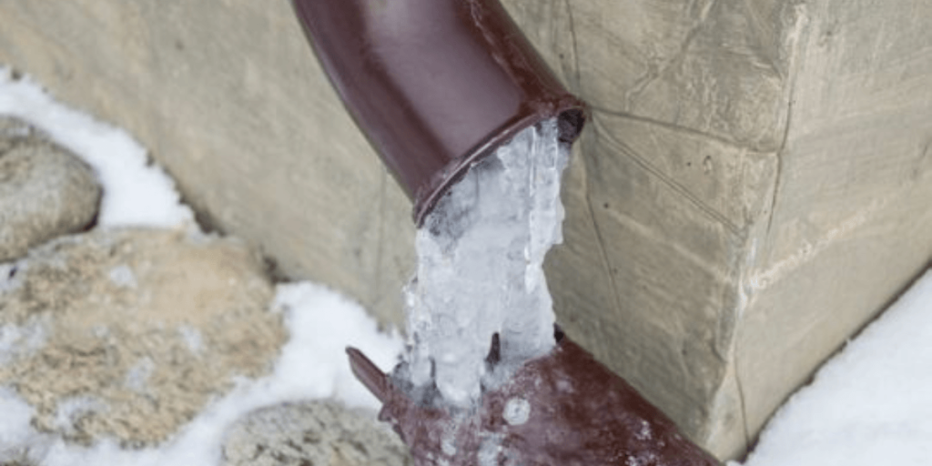 A pipe releasing a stream of ice, showcasing a unique contrast between metal and frozen water.