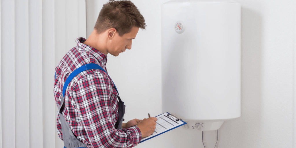 A man in blue overalls inspects a water heater, focusing on its components and functionality.